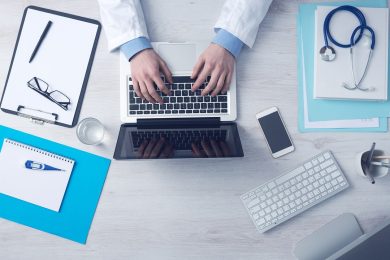 doctor typing on laptop
